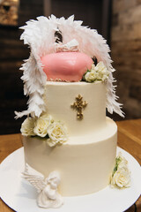 big white angel cake with wings and leaf with silver decor for baptism or wedding