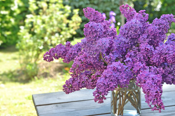 beautiful bouquet of purple lilac on a wooden table in garden