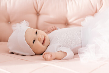 Obraz na płótnie Canvas Portrait of a cute 6-month-old baby, a newborn girl lying in a baby crib