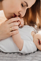 A loving mother carries her newborn baby at home. portrait of a happy mother holding a sleeping baby in her arms. Mother hugs her little 4-month-old daughter