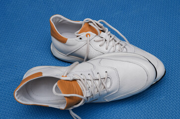 white sneakers with yellow inserts on a blue background