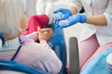 Adult giving a choice of two blue dental casts