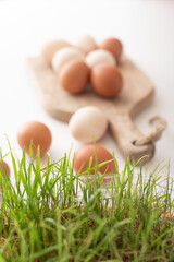white and brown eggs lie on a wooden board on a white table. home life. The process of preparing...