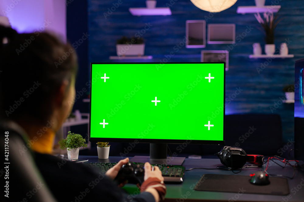 Poster pro gamer playing virtual videogames on professional powerful computer with green screen display. cy
