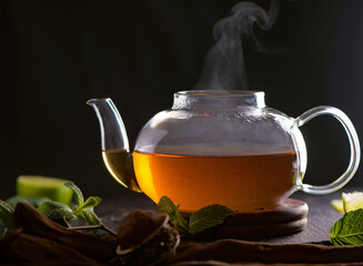 Tea concept, teapot with tea surrounded on wood background, tea ceremony, green tea in a...