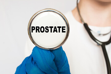 The doctor's blue - gloved hands show the word PROSTATE - . a gloved hand on a white background....