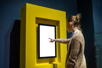 Woman hand using vertical white blank interactive touchscreen display of electronic multimedia...