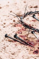 Fototapeta na wymiar Crown of thorns, bloody nails on sand background. Good Friday, Passion of Jesus Christ. Christian Easter holiday. Top view, copy space. Crucifixion, resurrection of Jesus Christ. Gospel, salvation
