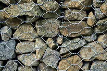 Beautiful close up high resolution view of gabion wall rocks and stones in metal wire box cage...