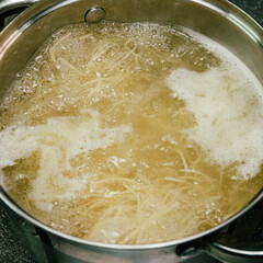 homemade noodles are cooked in a metal pot