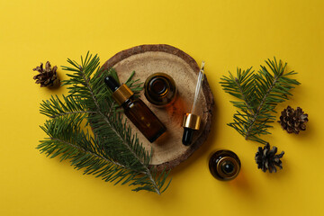 Fototapeta premium Aromatherapy concept with pine oil on yellow background