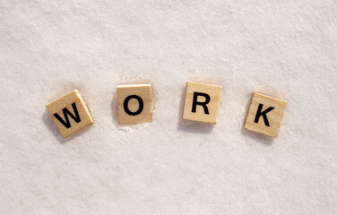 Work word on a white clean snow. Work phrase is written on a snow with wooden letters.