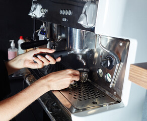Barista preparing coffee drink with espresso machine in coffee shop cafe
