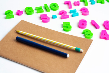 Mathematical exercises, notebook, pen and pencil on a white background