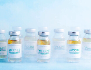 Coronavirus vaccine dose bottles on blue background covered in smoke. Kotsnept developing and testing a new vaccine in the laboratory