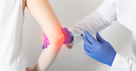 The doctor gives the patient an intra-articular injection of a blockade into the elbow joint....