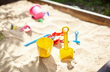 Sandbox outdoor. Children's wooden sandbox with various toys for the game - obrazy, fototapety, plakaty