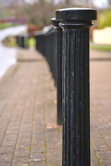 Beautiful vertical view of inline black metal road blockers to prevent vehicles getting parked on...
