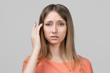 Fototapeta premium Concerned, frustrated young blond girl feeling fatigue, as suffer pain in head, painful headache or migraine