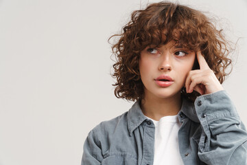Young ginger serious woman thinking and looking aside