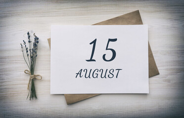 august 15. 15th day of the month, calendar date.White blank of paper with a brown envelope, dry bouquet of lavender flowers on a wooden background. Summer month, day of the year concept