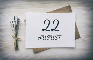 august 22. 22th day of the month, calendar date.White blank of paper with a brown envelope, dry bouquet of lavender flowers on a wooden background. Summer month, day of the year concept