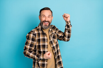 Photo portrait of aged man overjoyed laughing gesturing like winner isolated on bright blue color background