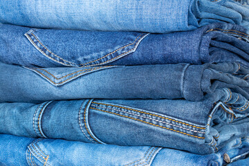 Fototapeta premium Denim trousers folded in a pile on a store window.