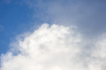 Detail of a white cloud in a bright blue sky. 
Dark rain clouds displace the blue sky. Storm is coming 