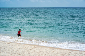 A boy playing in the sea in the morning on a fine day.