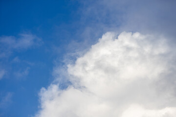 Detail of a white cloud in a bright blue sky. 
Dark rain clouds displace the blue sky. Storm is coming 