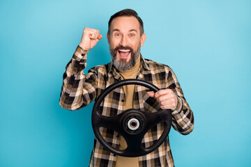 Photo portrait of man riding car keeping steering wheel gesturing like winner laughing isolated on vibrant blue color background