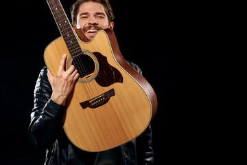 Obraz premium Cheerful man rock musician guitar playing music black background