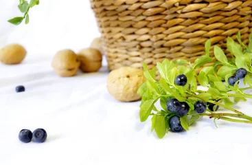 Foto op Plexiglas Still life of a basket, walnuts and branches of blueberries © Ekaterina