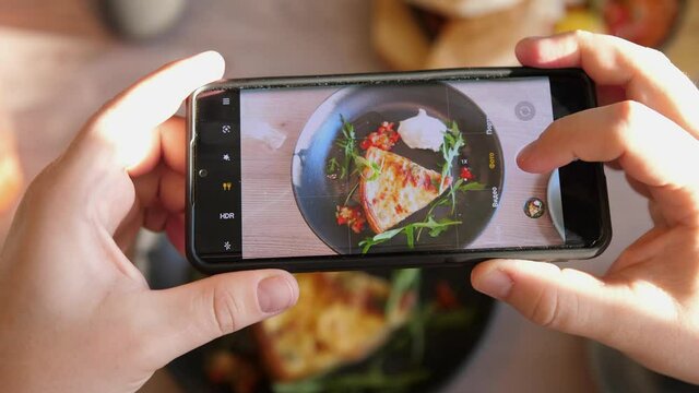 Male hands take photos of food of French quiche by modern smartphone. Closeup. 4K.