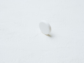 Pill of aspirin on white background.