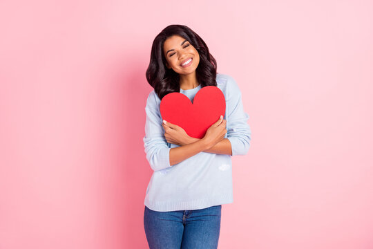 Photo of adorable lady embrace red paper heart figure wear blue pullover isolated pink background
