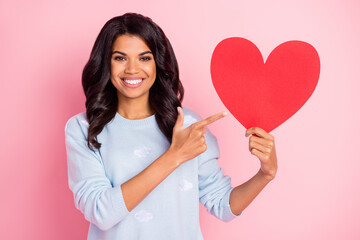 Photo of adviser lady indicate finger red paper heart card wear blue pullover isolated pink...