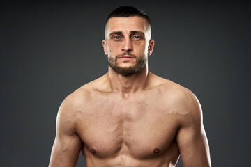 Fototapeta premium Bruised fighter on gray background
