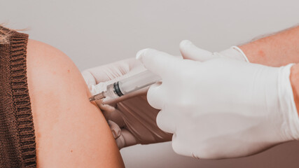 The laboratory assistant injects an antiviral into the patients hand, carrying out the procedure...