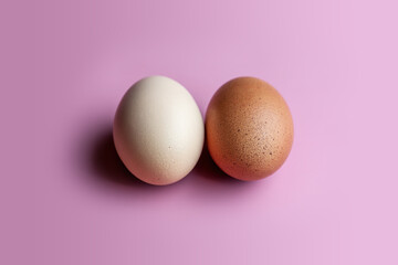Trendy Fuchsia Pink paired with a rustic egg. A dark and light egg lies on a pink solid background. 