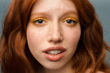 Young ginger white woman with makeup posing and looking at camera