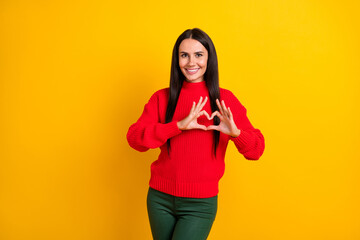 Photo of young beautiful positive smiling girl showing heart sign celebrate valentine day isolated on yellow color background