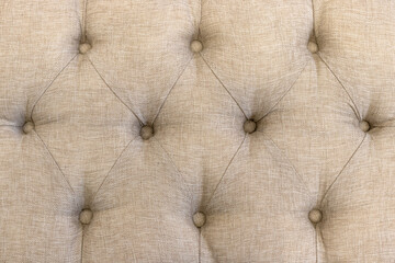 The surface of the fabric upholstery of the sofa with buttons.