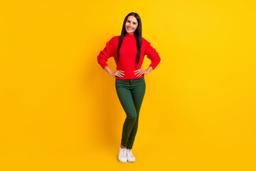 Fototapeta na wymiar Full size photo of young positive smiling woman wear red knitted sweater and green pants isolated on yellow color background