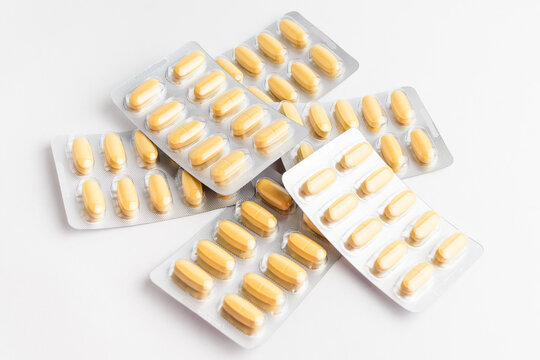 Close up of different medicine pills, tablets and vitamins isolated on white background, pharmaceutical picture taken with soft focus.