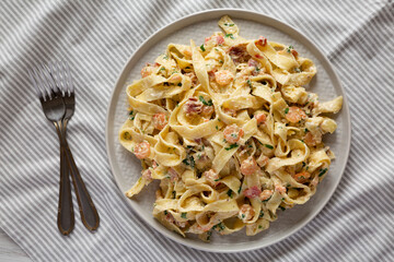 Homemade Garlic Shrimp Bacon Alfredo on a plate, top view. Flat lay, overhead, from above.