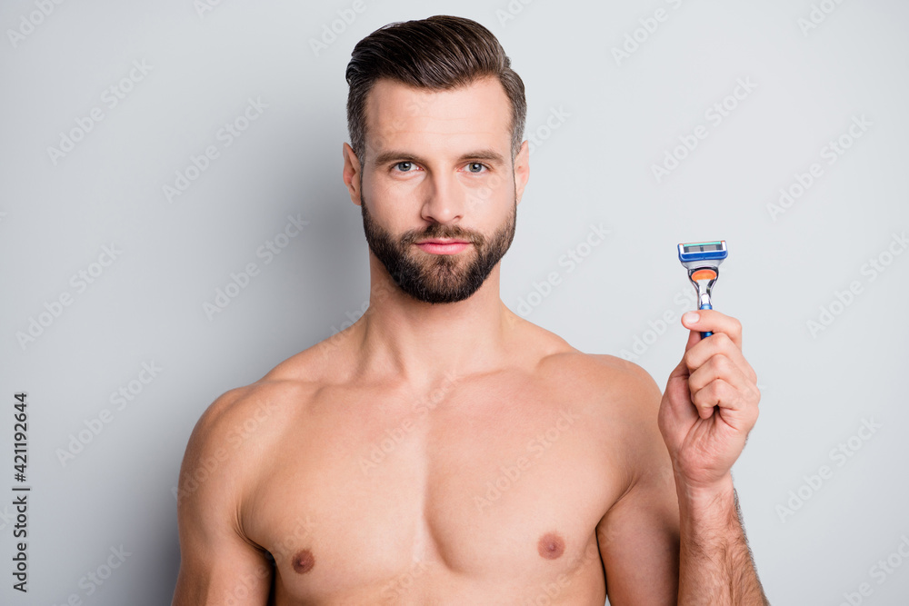 Sticker Photo of young handsome bristle man hold razor shave beard hygiene isolated over grey color background