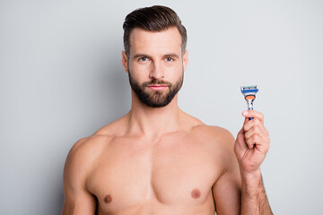Photo of young handsome bristle man hold razor shave beard hygiene isolated over grey color...