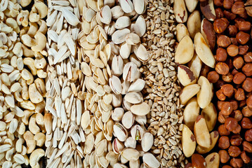 Many kinds of nuts close up. Heap of nuts on a black wooden board. Nuts are stacked on the table.